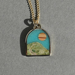 Necklace with a pendant featuring a landscape design on a gray background