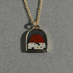 Necklace with a pendant featuring a sunset design on a gray background