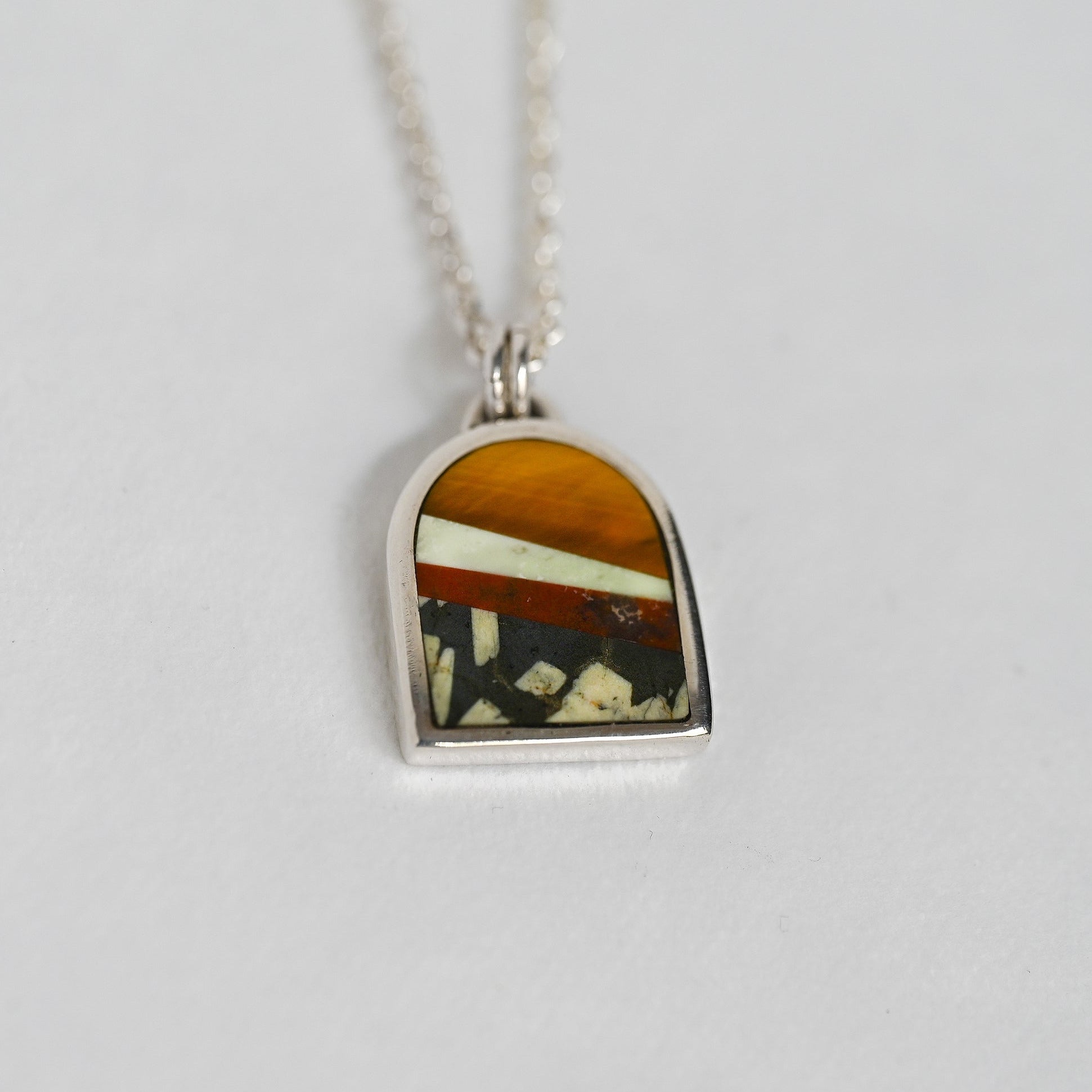 Necklace with a pendant featuring a multicolored stone on a white background