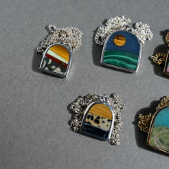 Set of miniature landscape pendants on a gray background