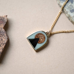 Necklace with a arch-shaped pendant on a neutral background