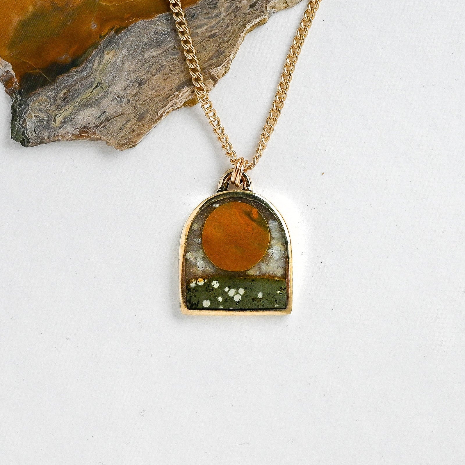 Arch shaped Necklace with a stone sun pendant on a white background