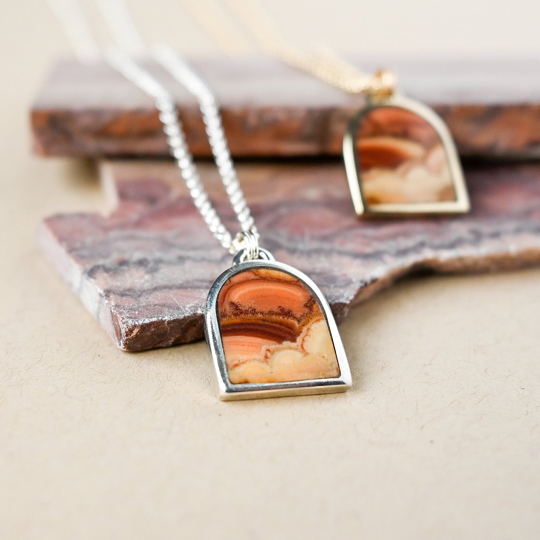 Sterling silver necklace with a wave dolomite pendant on a stone surface