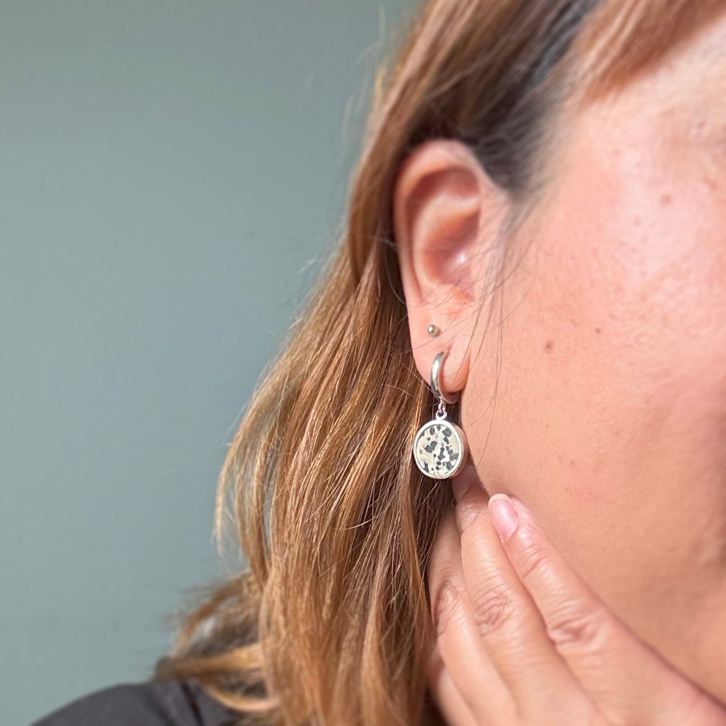 Woman wearing a dalmatian stone hoop earring