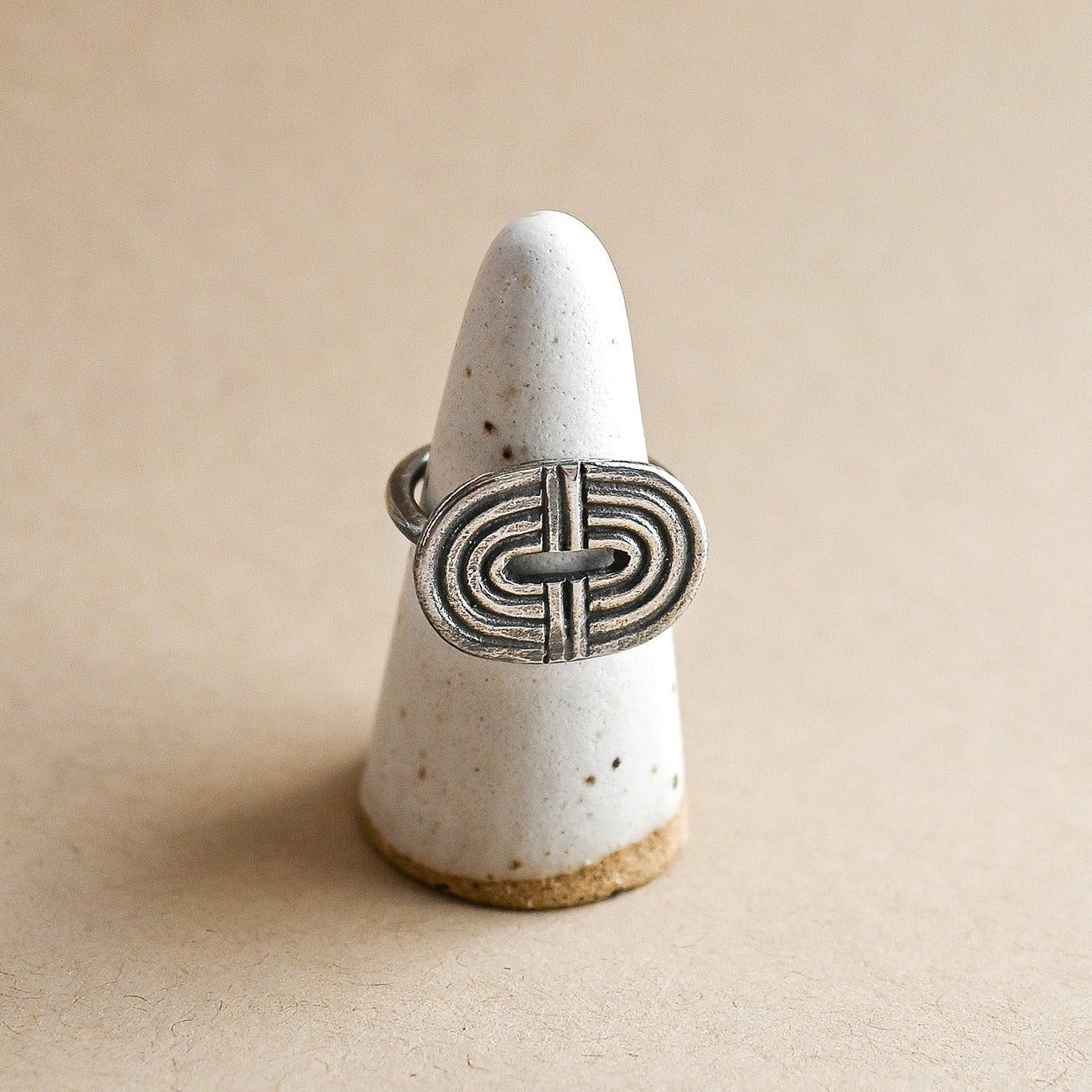 Sterling silver geometric rainbow ring on a ceramic ring form