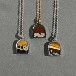 Three necklaces with unique pendants on a gray background