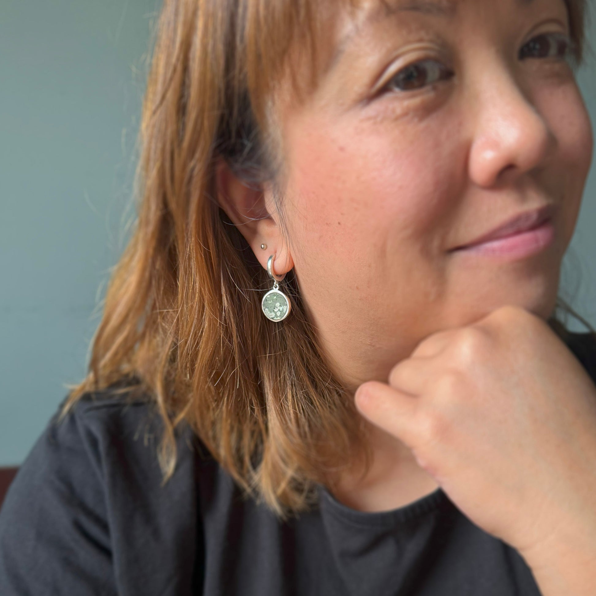 Woman wearing earrings with a neutral background